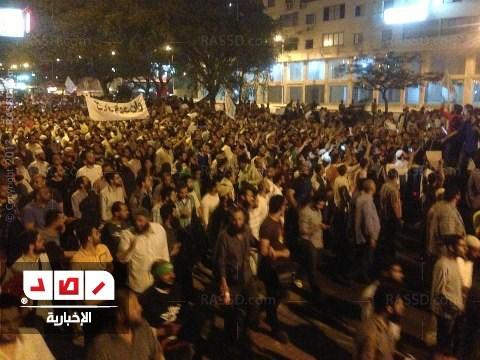 متظاهر ينزل علم الأمن الوطني ويرفع علم التوحيد